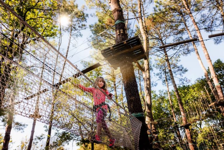 Une jeune fille fait de l'accrobranche à Saint-Molf au Camping Paradis l'Île de Kernodet